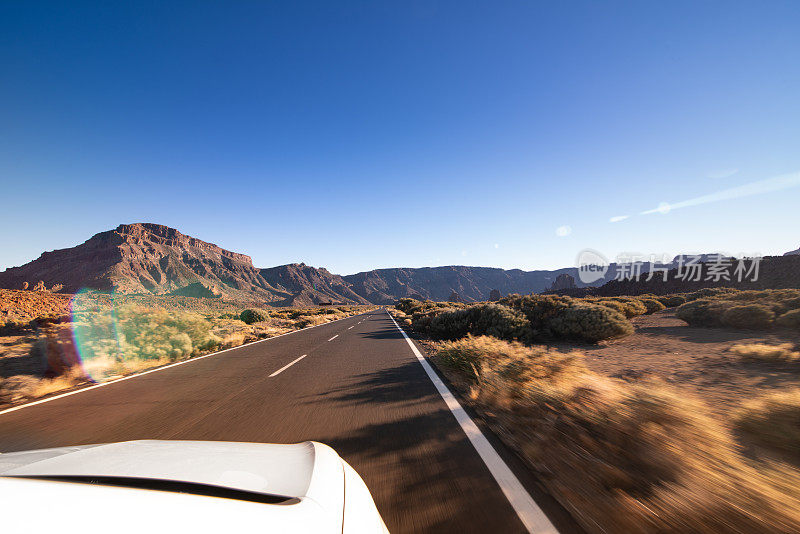 水平视图与模糊运动的高速公路上行驶在日落在加拿大del Teide，国家公园del Teide，特内里费，加那利群岛，西班牙-股票照片